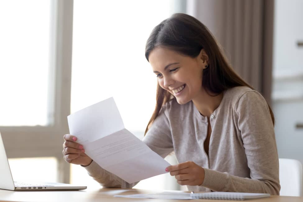 Happy woman reading loan prequalification letter