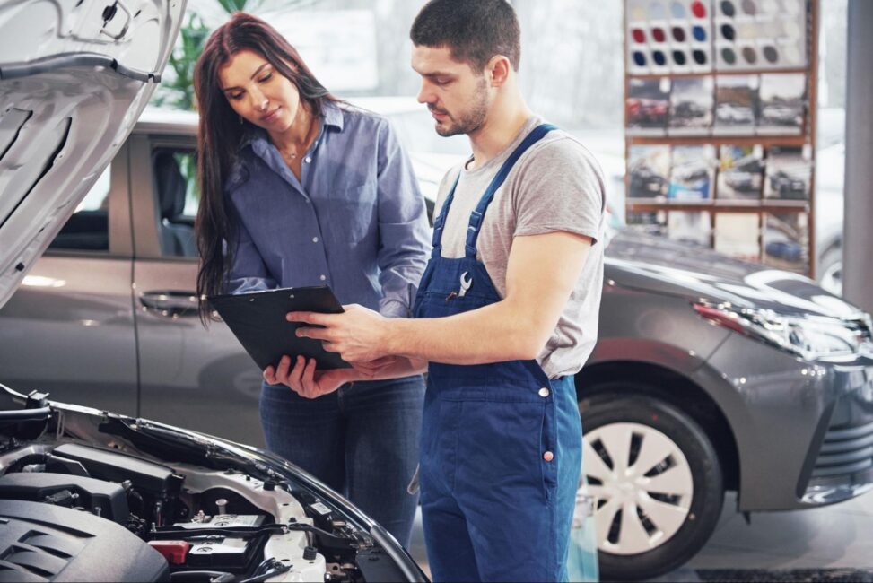 Mechanic reviews clipboard with a customer to discuss auto repair financing