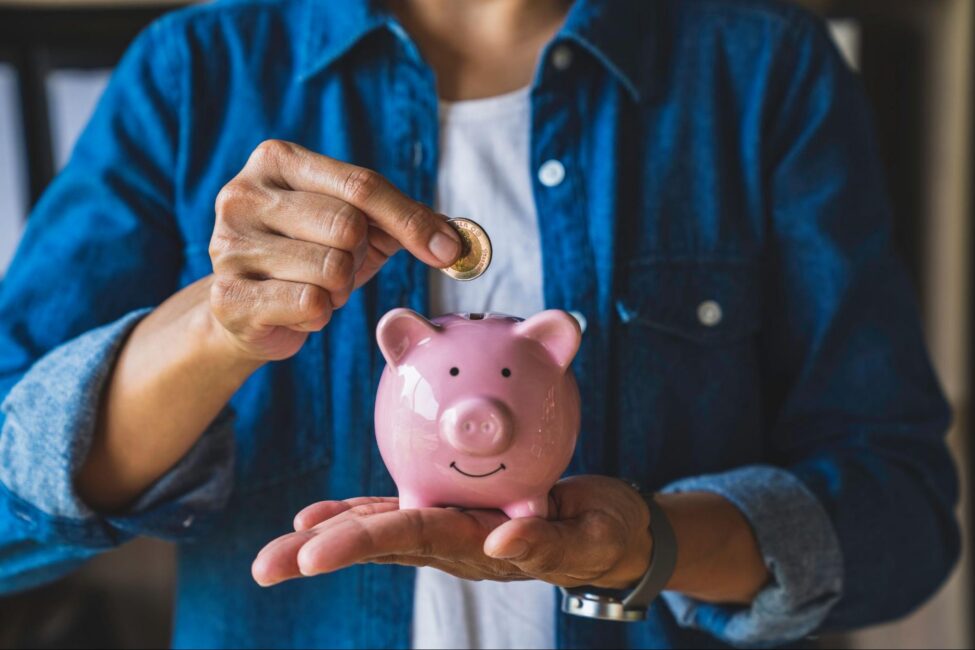 Man holding a piggy bank to represent a savings accountÂ