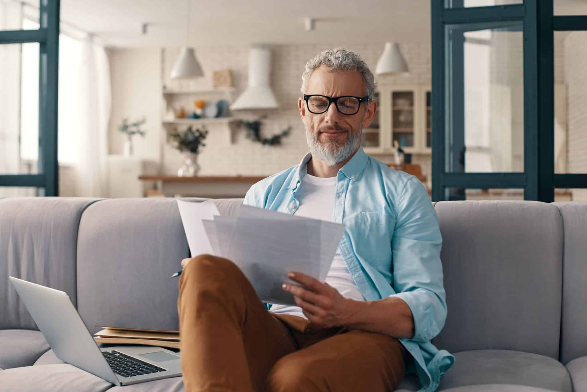 Man reviewing documents to open a bank account at home