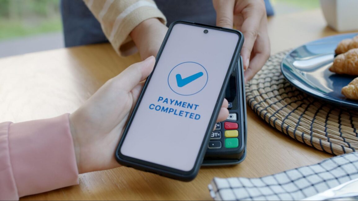 A person completing a mobile transaction, showing a “payment completed” screen