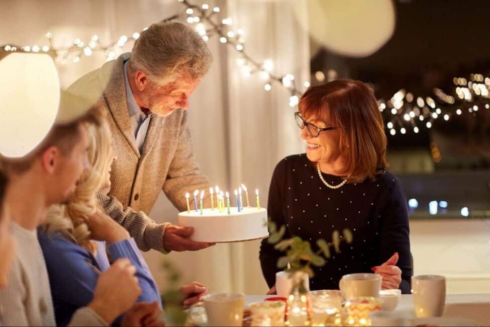 A family gathers around a lit cake for a cozy birthday party on a budget at home