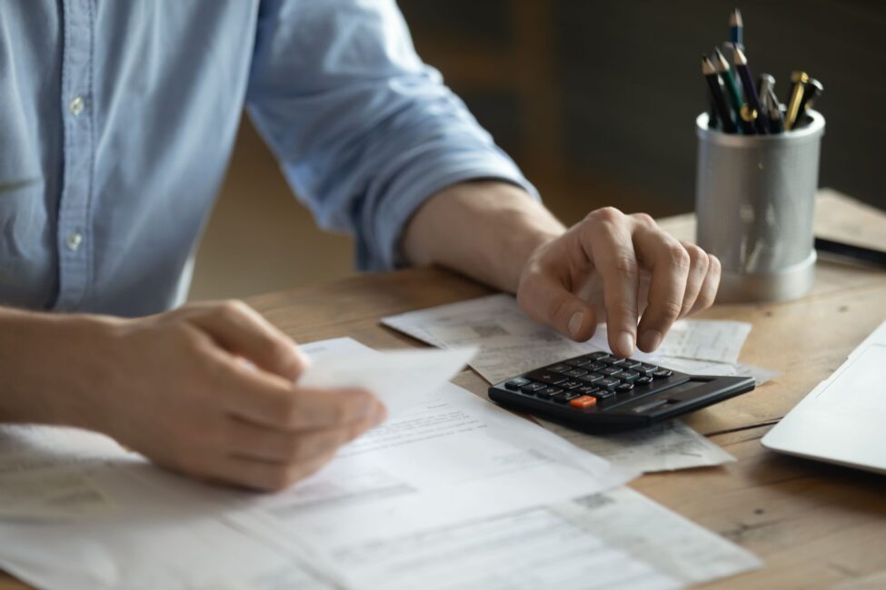 Man gathering tax documents and calculating annual earnings to ensure accurate figures on the 1099-NEC form